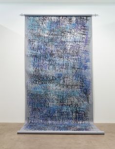 an abstract painting on display in a white room