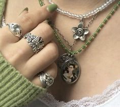 a woman wearing rings and necklaces with pictures on them