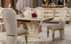 a dining room table with chairs and a vase on top of it in front of a mirror