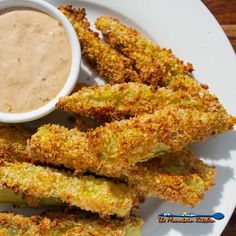 fried asparagus with dipping sauce on a white plate