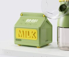 a green and yellow milk dispenser sitting on top of a white shelf