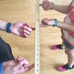 two people standing in front of a measuring tape