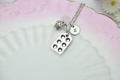 "This is a silver-tone baking pan and cupcake charm with hand stamped initial charm on a chain. You able to choose initial charm from a drop-down menu. You able to choose as a necklace, bracelet chain, bangle or key chain. ♥ You will receive 1 necklace ♥ Charm zinc metal alloy baking pan 22 x 13 mm., cupcake 14x10mm. ♥ Initial charm stainless steel 10mm, choose from a drop-down menu. ♥ Keyring 30mm or Necklace approx. 18 inches (either stainless steel or brass) or Bracelet chain 6 1/2 with 2 inc Nickel-free Silver Charm Necklace For Birthday, Silver Stamped Charm Necklace For Birthday, Silver Hypoallergenic Charm Necklace For Birthday, Cupcake Necklace, Cupcake Charms, Silver Keychain, Nana Gifts, Bracelet Chain, Baking Pan