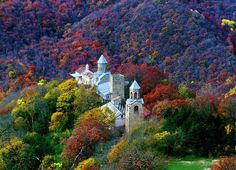 an old church surrounded by trees in the fall