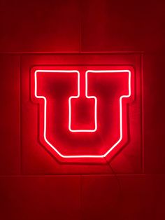 a red neon sign with the letter u on it