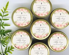 six personalized wedding favors in gold tins with floral designs and names on them