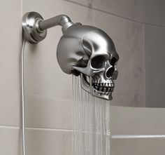 a skull head shower faucet with water coming out of it's side