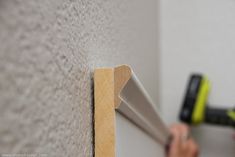 a person using a hammer to attach a wall