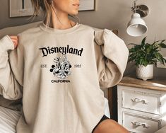 Disneyland California Sweatshirt,Retro Mickey And Friends Disneyland Est 1955 Sweater,Disneyland Shirt,Family Vacation Shirt,Disneyland TEE We design trendy sweatshirts that you can use in every important day of your life. We produce beautiful and quality designs that can be used in all kinds of activities that you will do with your family or friends. These designs will offer you and your environment a unique complement. We are very excited to bring you our high quality and soft, trendy sweatshi Disney Christmas Gifts, Ballerina Silhouette, Outlander Book Series, Designed Shirts, V Neck Shirts, Elizabeth Bennet, Outlander Book, Funny Mom Gifts, Psalm 91