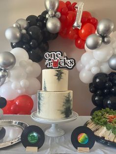 a table topped with a cake and balloons