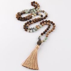 Bohemian Tribal Stone Beaded Necklace with Tassel Pendant Stylish Design Discover the beauty of nature and fashion with this statement necklace showcasing an intricate BOHO tribal stone design. This sophisticated, long strand necklace is the perfect addition to any chic look. Quality Materials Crafted with: Metal: Alloy Material: Semi-Precious Stone Perfect Length With a chain length of 104cm and a pendant length of 10.0cm, this necklace is designed to enhance your wardrobe effortlessly. Timeles Adjustable Bohemian Long Necklace With Tassels, Bohemian Long Necklace With Wooden Beads, Bohemian Long Necklace With Tassels, Bohemian Wooden Beads Mala For Festival, Bohemian Festival Mala With Wooden Beads, Spiritual Beaded Tassel Necklace For Beach, Bohemian Long Adjustable Necklace With 108 Beads, Bohemian Long Necklace With 108 Adjustable Beads, Bohemian Long Necklace With Natural Stones For Beach