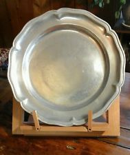 a silver plate sitting on top of a wooden stand