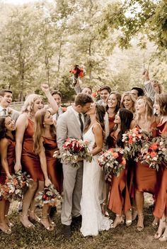 a group of people standing next to each other in front of some trees and flowers