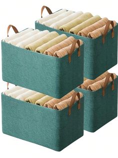 three teal storage baskets with brown handles