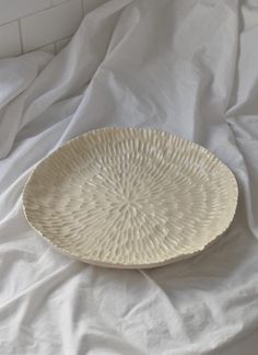 a white plate sitting on top of a bed