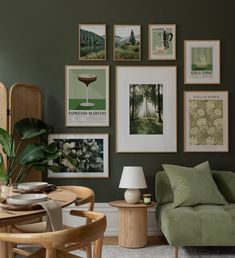 a living room with green walls and pictures on the wall above the couch, table and chair