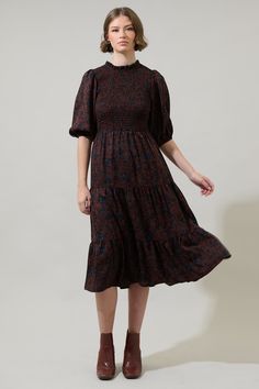 The Kalida Beau Frazier Smocked Tiered Midi Dress is reminding us of all the reasons to feel gratitude. Full, short puff sleeves frame a flattering smocked bodice that tops a flowy, tiered midi skirt. A keyhole sits at the top of the back to make getting in and out easier. Wear it to any event with your favorite accessories and boots to complement the look.- Smocked- Keyhole- Tiered- Bubble sleeves- Color: ChocolateSize + Fit - Model is 5'10" and wearing size XS- Measurements taken from size S - Modest Smocked Dress With Puff Sleeves, Fall Smocked Dress With Short Sleeves, Modest Fitted Smocked Dress With Short Sleeves, Brown Smocked Back Dress For Fall, Fall Midi Dress With Smocked Bodice And Short Sleeves, Modest Smocked Ruched Short Sleeve Dress, Fitted Smocked Dress With Elastic Short Sleeves, Fall Smock Dress With Short Sleeves, Brown Smocked Dress For Fall