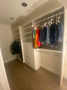 an empty closet with clothes hanging on hooks