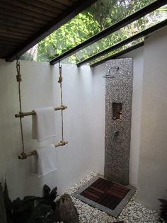 a bathroom with a stone shower and white towels