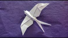 an origami bird on a purple background