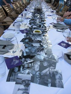 a long table with many pictures on it and wine glasses sitting next to each other