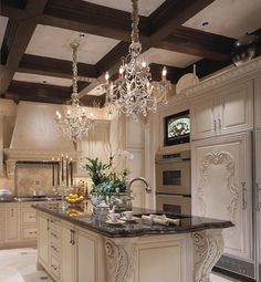 a fancy kitchen with chandelier and marble counter tops, white cabinets and an island in the middle