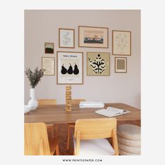 a dining room table with chairs and pictures on the wall