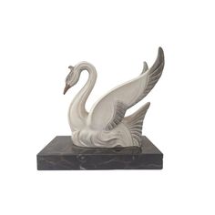 a statue of a swan on a marble base