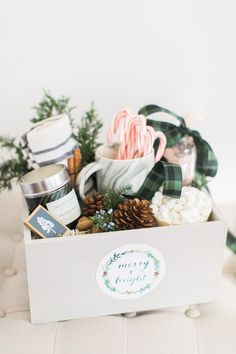 a christmas gift box filled with candy canes, marshmallows and cookies