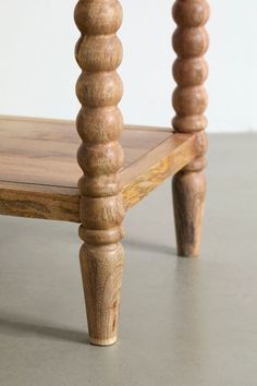 a wooden table with two legs and a wood top that has turned to look like columns