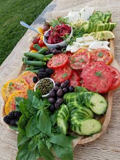 a platter filled with lots of different types of fruits and vegetables on top of a table