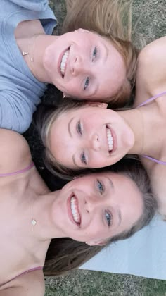 three women laying on the ground with their arms around each other