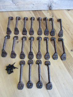 an assortment of metal handles and knobs on a wooden surface