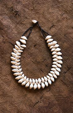 This African Collar Cowrie Shell Jewelry is a beautiful statement necklace, handmade with authentic cowrie shells. It's a perfect accessory to take any outfit from simple to stunning. Add a touch of elegance to your wardrobe with this unique statement piece. Length: 9 inches Inventory # 10848 Traditional Cowrie Shell Jewelry, Cowrie Shell Jewelry Necklaces, Cowrie Shell Jewelry, Cowrie Shell Necklace, African Accessories, Shell Pattern, Cowrie Shell, African Jewelry, Shell Jewelry