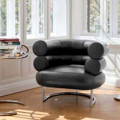 a black leather chair sitting in front of a window