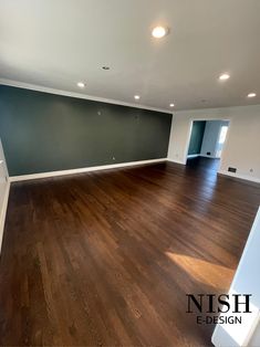 an empty room with hard wood floors and green walls