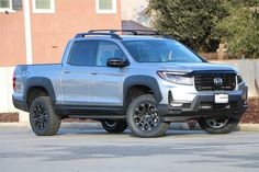 a silver truck parked in front of a building