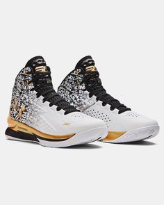 the nike zoom basketball shoe is white and black with gold details on the upper part