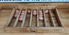 a crate filled with lots of eggs sitting on top of a wooden floor next to a sign