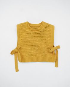 a knitted sweater with ties on the front and back, in mustard yellow color