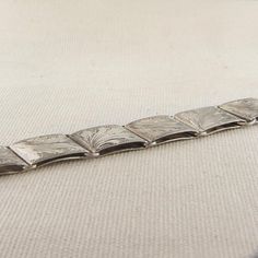 This Vintage Silver link bracelet has a hand engraved nature inspired leaf pattern on each link. The total length of bracelet measures 7 3/4". This bracelet is stamped '835.'Total Weight: 29.9gThese pieces are pre-owned vintage jewelry. As this jewelry is not new there may be signs of wear or age. Each piece is sold as-is unless otherwise specified (ex. sizing). We strive to only sell vintage jewelry that is in good wearable condition. As with any jewelry, care and proper maintenance is key to l Rectangular Metal Bracelets Engraved, Adjustable Engraved Bracelets For Formal Occasions, Silver Link Bracelet, Lock Style, Rose Bracelet, Green Jewelry, Sterling Silver Cuff Bracelet, Gold Cross, 14k Gold Ring