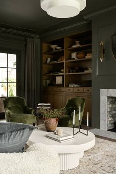 a living room filled with furniture and a fire place in the middle of a room