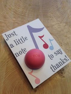 a red ball sitting on top of a card that says just a little note to say thanks