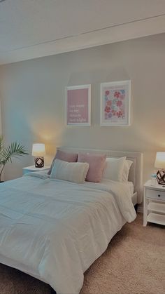 a white bed sitting in a bedroom next to two lamps on either side of the bed