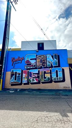 a large mural on the side of a building in front of a parking lot and telephone pole