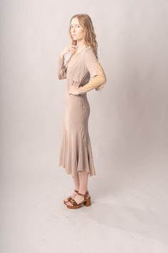 Stunningly preserved 1920’s mauve & ecru bias cut dress with attached jacket, lace trim, and asymmetrical cut. Best fits modern size S-M Length 52”Pit to pit 18.5”Waist 26-30”Hips 31-42” Model’s Measurements:Height 5’9”Chest 34”Waist 29”Hips 36.5” Excellent vintage condition, with normal wear and condition for its age.For international shipping rates, please send inquiries to our CONTACT page. Fitted Lace Trim Midi Dress For Fall, Fitted Bias Cut Dresses For Fall, Cream Fitted Midi Dress With Lace Trim, Fitted Cream Midi Dress With Lace Trim, Fitted Long Sleeve Bias Cut Midi Dress, Fitted Taupe Midi Dress, Taupe Fitted Midi Dress, Spring Flapper Dress Fitted, Fitted Taupe Midi Length Dress