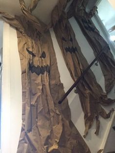 an image of a halloween scene made out of brown tissue paper and black bats on the wall