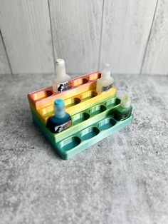 a multicolored tray with bottles and soaps in it sitting on a table