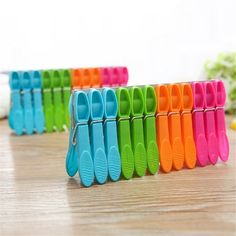 several different colored toothbrush holders on a wooden table