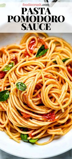 pasta with tomato sauce and basil leaves in a white bowl on top of a table